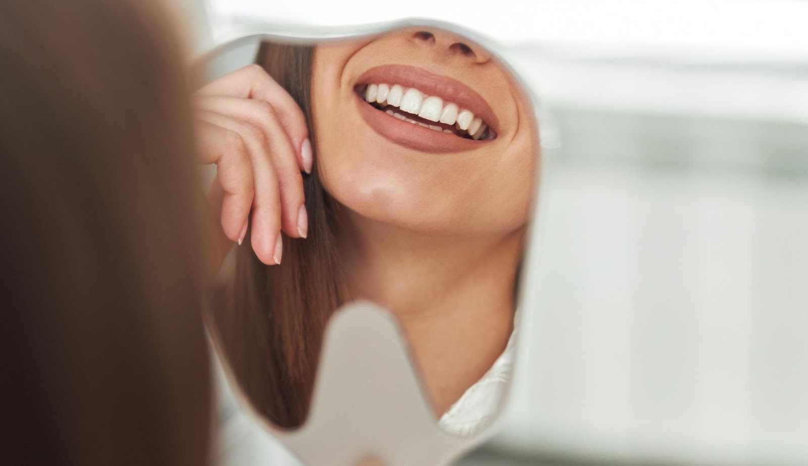 Femme souriant après avoir reçu un traitement dentaire en Albanie