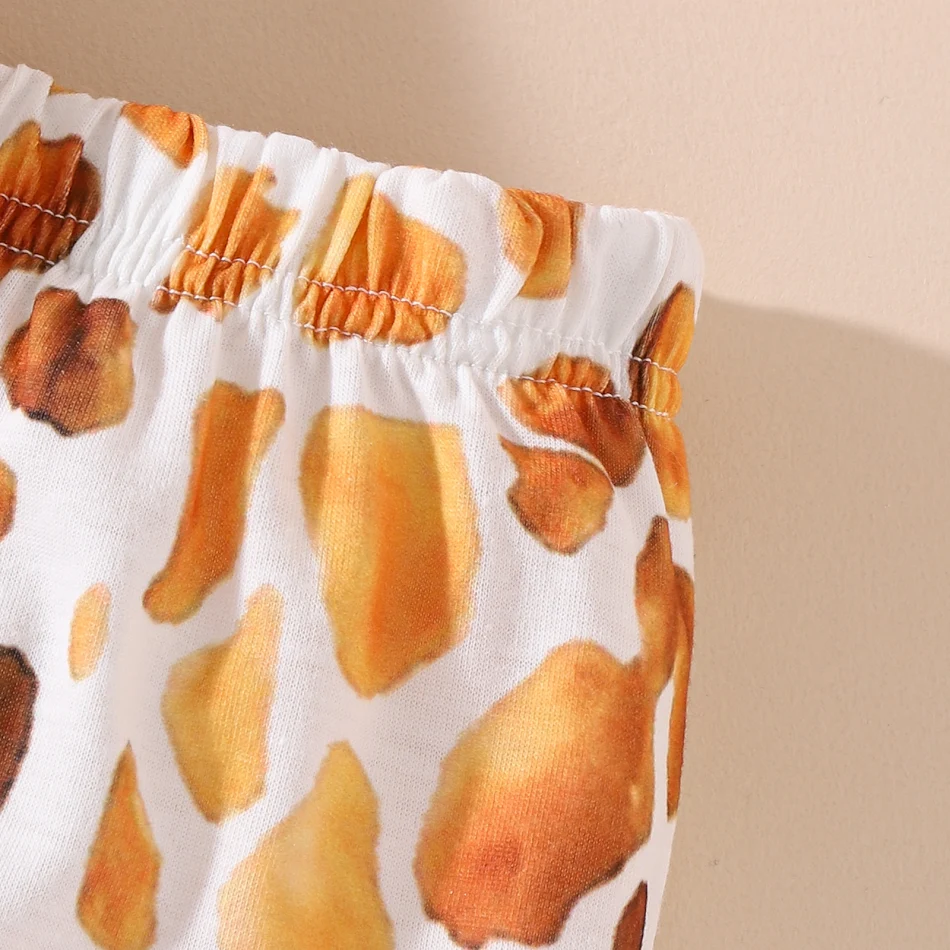 Schattig wit T-shirt met cartoon giraffe en een short met stippen, perfect voor kids om in te spelen en te ravotten.