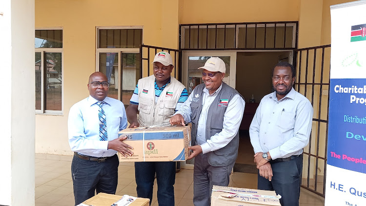 Alietisam public relations officer Hussein Mwange hands over medical supplies to Kwale Health executive Francis Gwama at Kwale hospital in Matuga on Tuesday, February 22, 2022.