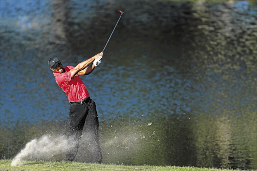 Tiger Woods plays his dropped ball on the 14th hole on his way to victory in the Players Championship at TPC Sawgrass in Ponte Vedra Beach, Florida, on Sunday