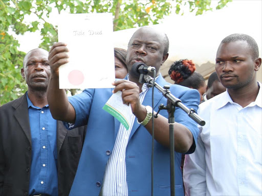 Governor Khaemba issuing land titles in Kitale recently.Photo/Mathews Ndanyi