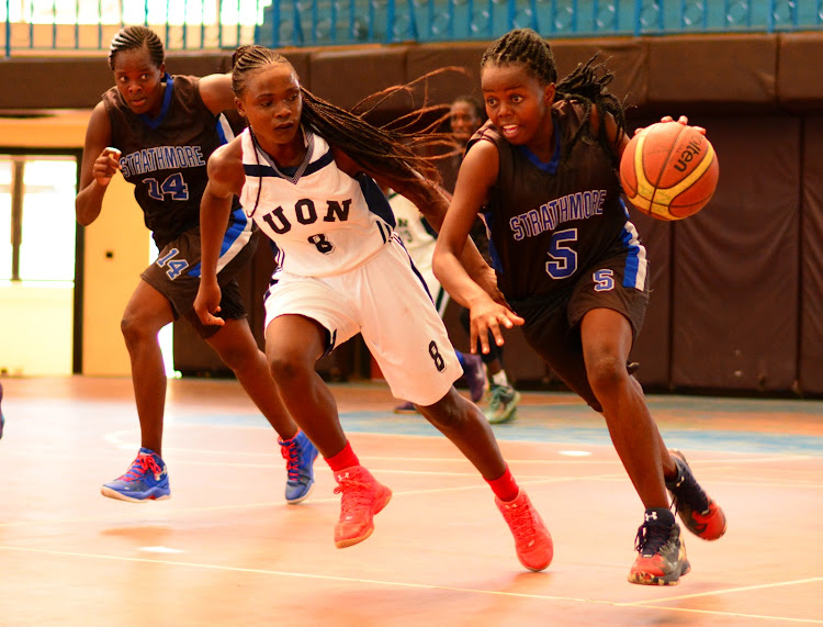 Strathmore's Damaris Riana (R) charges past Elizabeth Okumu of UON Dynamites during their league match at Nyayo Gymnasium recently