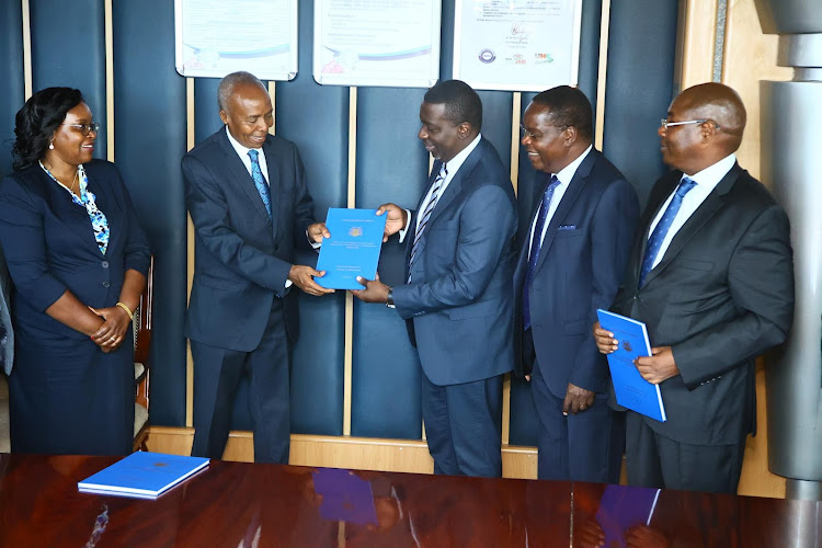NHIF Board chairperson Michael Kamau receives a copy of the report from the Social Health Authority chairperson Timothy Olweny during the launch of the report at NHIF on March 5, 2024