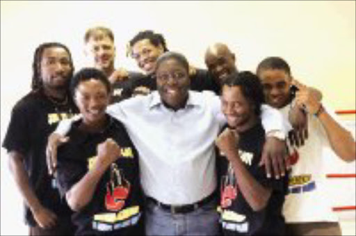 PACKING PUNCH: Boxing promoter Mohloyoa seoe, centre, is flanked gy boxers from top boxing mentor Johnny du Plooy, second from left, during the signing of a contractual agreement. The boxers are, back row from left, Bongani Mahlangu, Tshepang Mohale, Bongani Mwelase and Bongani Dlamini. Front row: Gideon Zulu, left, and Nelson Mtshali. Pic. Antonio Muchave. 05/12/07. © Sowetan.