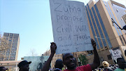 #OccupyLuthuliHouse protester hold a placard 'Zuma promotes War'