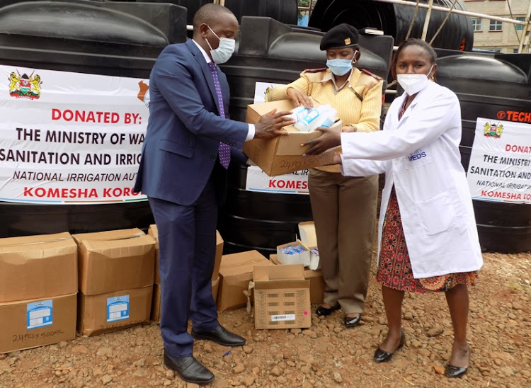 Water, Sanitation and Irrigation CS Sicily Kariuki's legal adviser Nderi Ndiani, Embu West deputy commissioner,Caroline Imaya and Embu chief Health officer Grace Muriithi during distribution of water tanks and other items donated by Water Irrigation Authority on Monday, June 22, 2020.