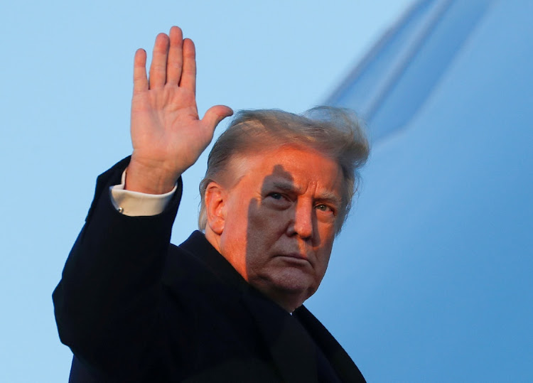 US President Donald Trump waves as he boards Air Force One at Joint Base Andrews in Maryland, US, December 23, 2020.