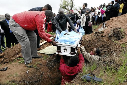 Mourners lower the coffin of rape/murder victim Sanelisiwe Mhlongo, 4, into her grave in KwaMashu. An uncle age 15 has been arrested in connection with the crime.