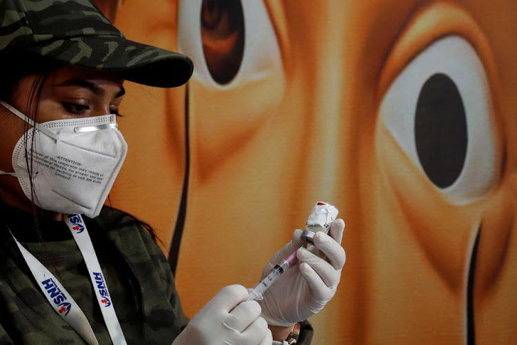 A healthcare worker fills a syringe with a dose of the COVAXIN coronavirus disease (COVID-19) vaccine manufactured by Bharat Biotech, during a vaccination drive for children aged 15-18 in New Delhi, India, January 3, 2022