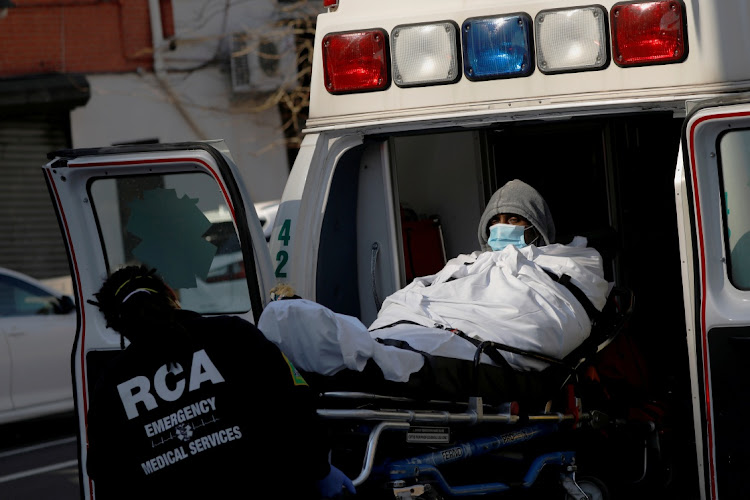 EMT's load a patient into an ambulance as health workers continued to test people for Covid-19 outside the Brooklyn Hospital Center in Brooklyn, New York City.