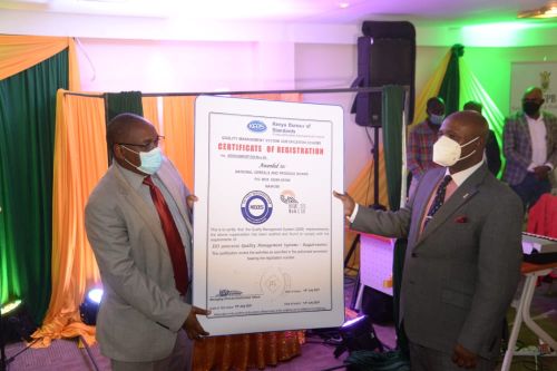 Agriculture PS Hamadi Boga presents the ISO certificate to the National Cereals and Produce Board managing director Joseph Kimote.