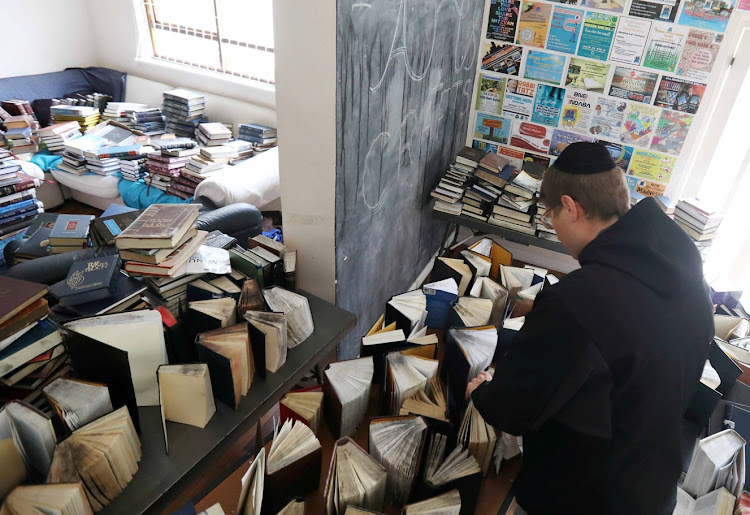 A member of the congregation at Arthurs Road synagogue in Sea Point, Cape Town, begins efforts to save some of the books rescued from a fire on Tuesday December 4, 2018.