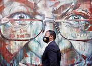 A person walks past Archbishop Emeritus Desmond Tutu's mural in Cape Town's CBD on his birthday.