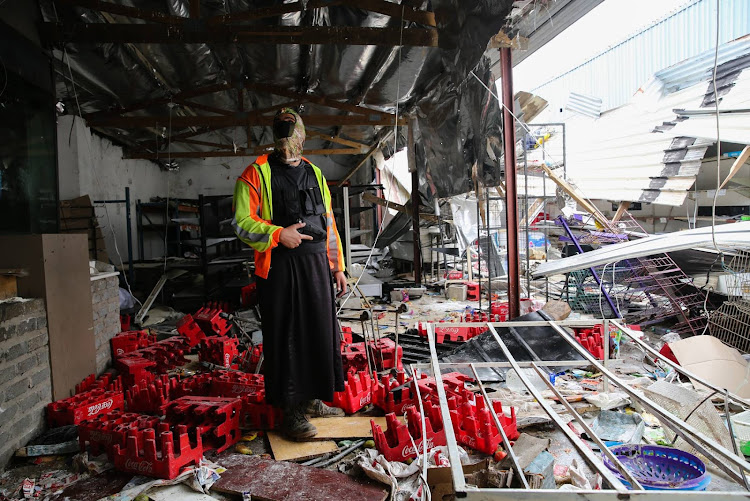 A shopkeeper guards what is left of his northern areas shop which was looted on April 14