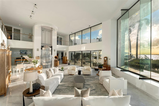 Large white living room ocean sunset view in this luxury house for sale in Key Biscayne ($237,000,000 - 1,071 m²)