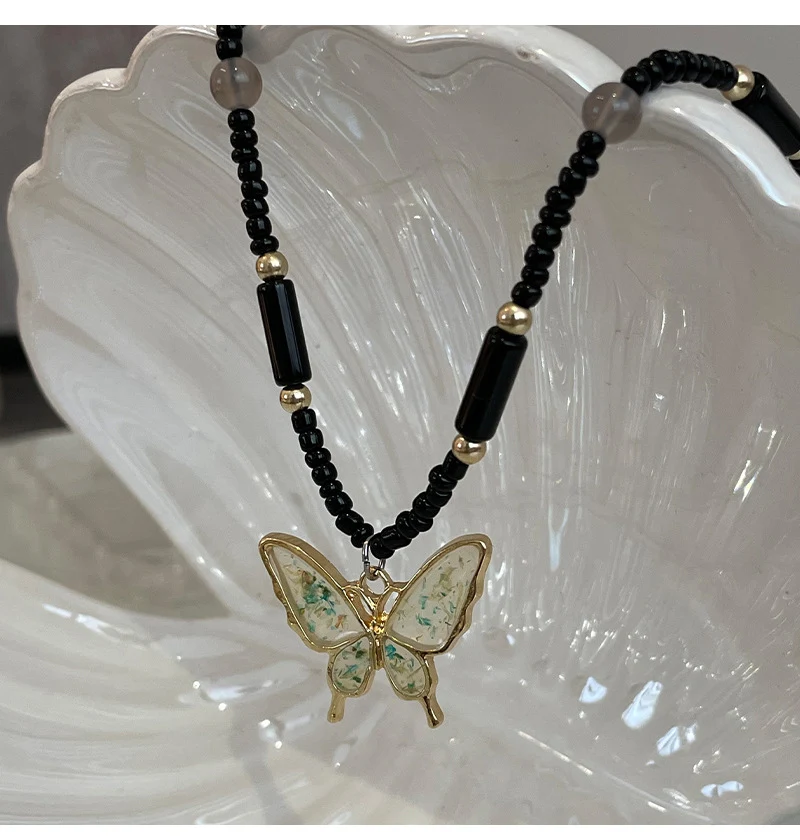Title 3, Collier pendentif papillon perlé noir Un bijou ...