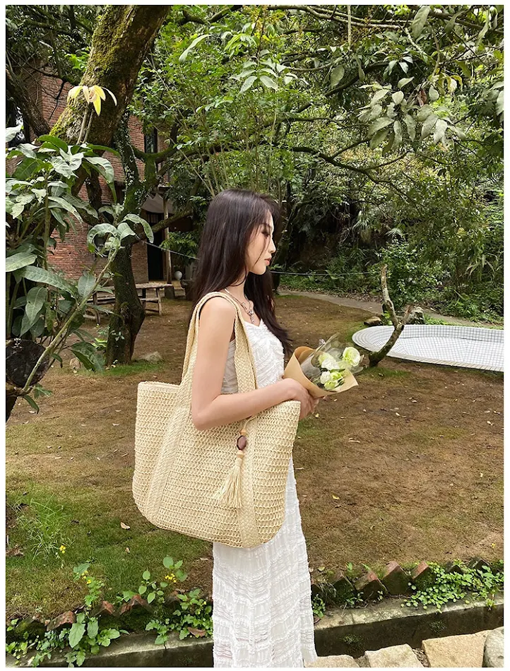 Bolsa feminina casual de praia com alça de ombro, palha e pingente de mogno, perfeita para um look fashion e leve.