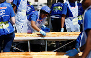 Clover employees assist at Maponya Mall in Soweto during an attempt to set a new world record for the longest line of sandwiches.