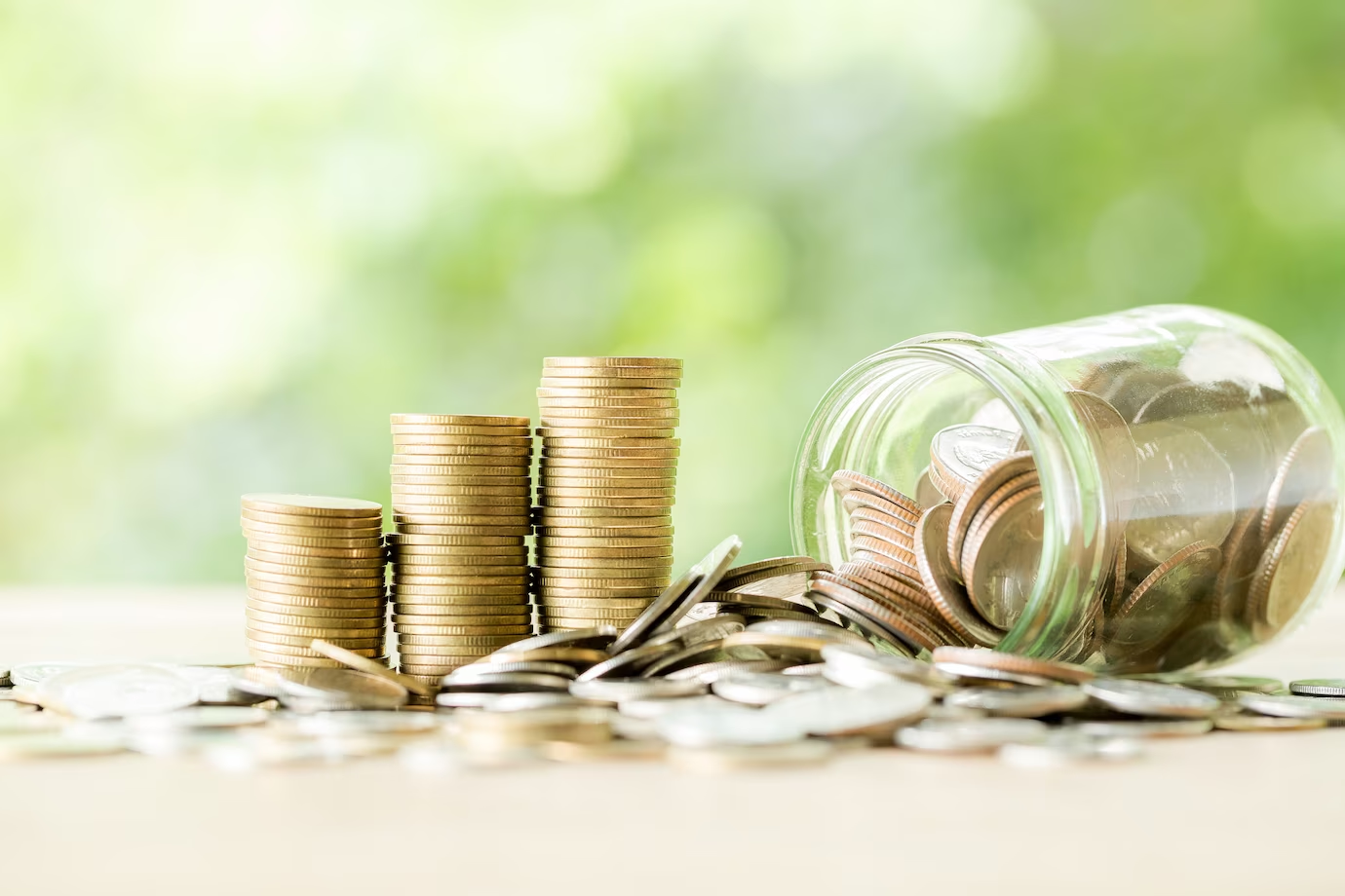 Coins on the wooden table representing student loan expenses.