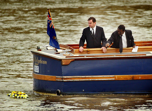 Detective Inspector Will O'Reilly (L) and John Azah of the Independent Advisory Group place a wreath in the River Thames at the place where the torso of a boy, who police have called 'Adam', was found in 2001.