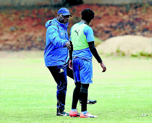 Downs coach Pitso Mosimane gives last- minute instructions to Percy Tau on Wednesday before leaving for Egypt to play Zamalek. PHOTO: Samuel Shivambu/ Backpagepix