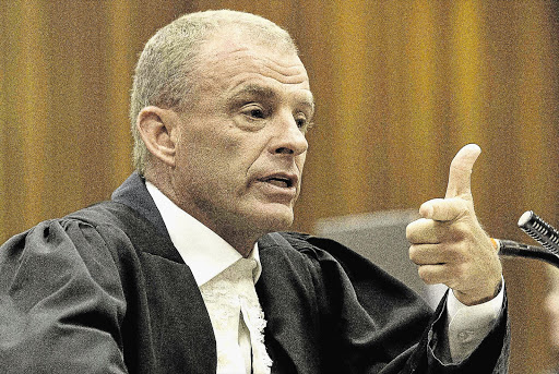 TRIGGER-UNHAPPY: Prosecutor Gerrie Nel takes aim at Oscar Pistorius's version of the Valentine's Day shooting of his girlfriend