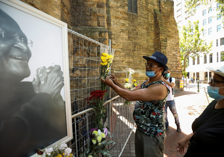 Mourners pay their respects to the late Archbishop Desmond Tutu outside St Georges Cathedral in Cape Town, South Africa, December 26, 2021.