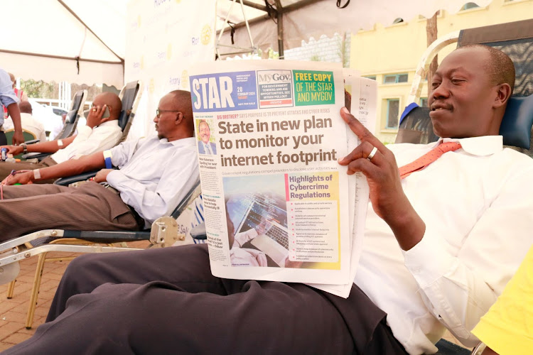 A Machakos County Assembly staff reads the Star Newspaper as he donates blood at the assembly's premises in Machakos County on February 21, 2024.