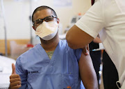 A health worker is vaccinated at Khayelitsha District Hospital in Cape Town. The AU supports calls for drug makers to waive some intellectual property rights on Covid-19 medicines and vaccines to speed up their distribution to poor countries.