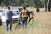 Members of the CPF walk through the veld close to the area where a tiger has escaped in Walkerville, south of Johannesburg, on January 16 2023.