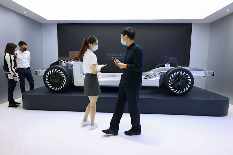 People wear protective masks as they get a look at the A Voyah EV model car during the 2020 Beijing International Automotive Exhibition at China International Exhibition Centre on September 27, 2020 in Beijing.