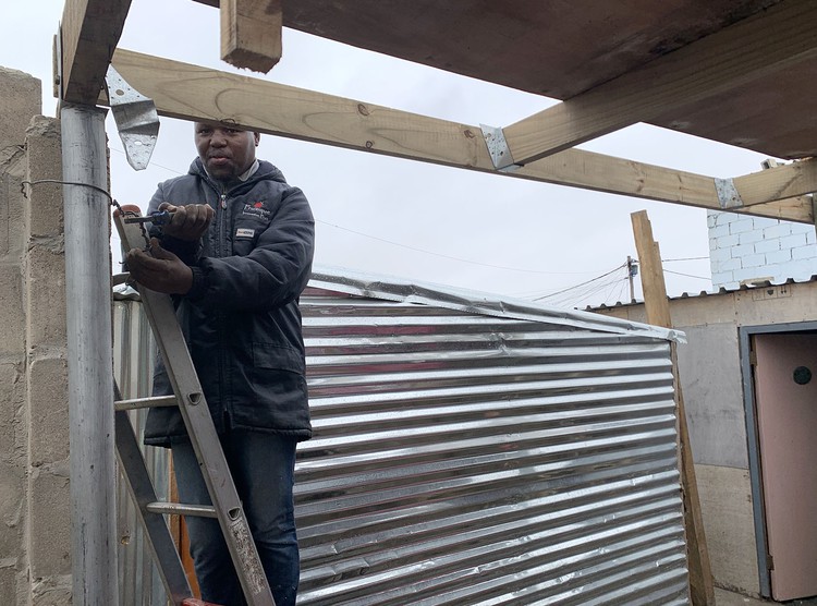 Adding a second storey to his shack, built on the illegally occupied municipal sports field in Dunoon, Yanga Nkohla says land was prioritised for golf courses rather than houses 'because white people don’t want us close to them'.