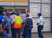 Chris Gagiano (in glasses) outside his home in Edenvale as members of the SPCA and SAPS enter the premises after a search warrant was served on Wednesday.