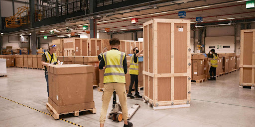 Workers moving containers inside a factory 