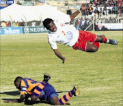 IN FULL FLIGHT: Siyabulela Songwiqi, airborne is tackled by Elasto Kapowenzha during the National First Division final match between Bay United and FC AK at Woolfson's Stadium in Port Elizabeth. Pic. Lee Warren. 13/07/2008. © Gallo Images