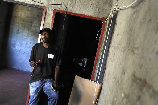 A local resident, who refused to be named, fixes electrical wires in a house.