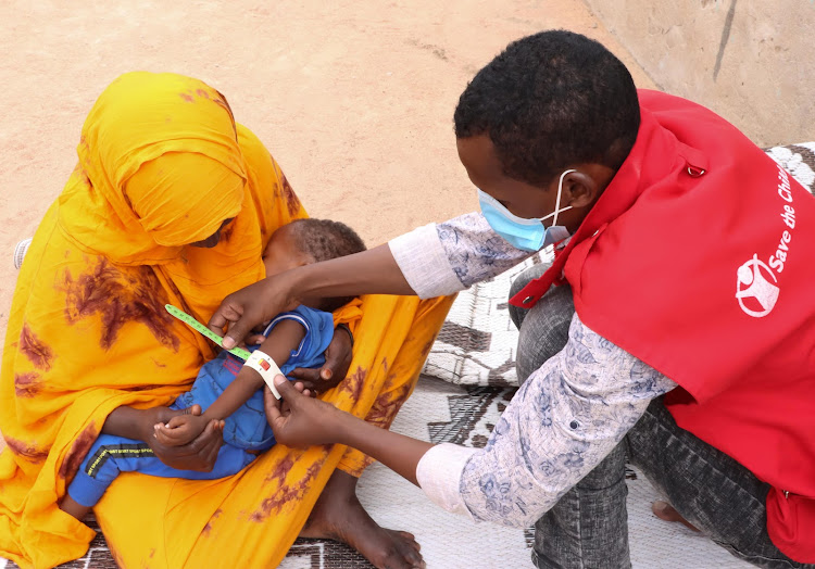 A nutritionist uses a MUAC tape to screen Mubarak for malnutrition in Wajir