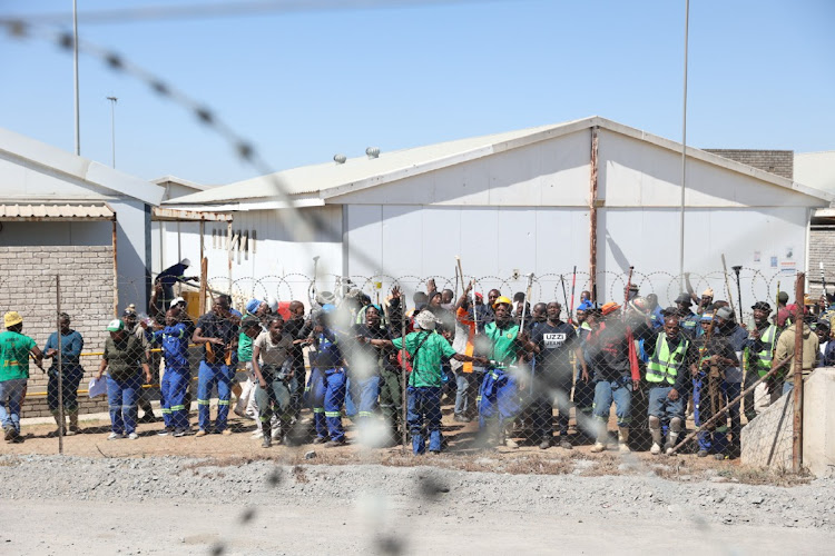 AMCU mineworkers singing inside the Gold One mine premises. More than 100 of the 500 miners have escaped after been held hostage for two nights underground at Gold One mine in Springs.ed as representing the workers.