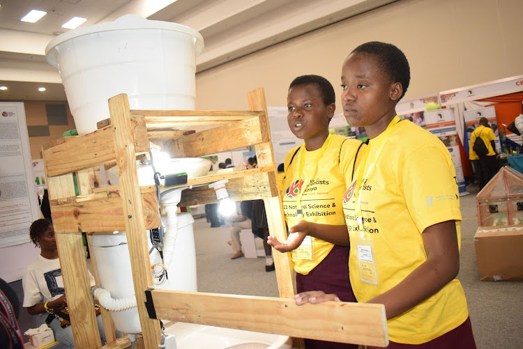 Manyala Mitchel and Markrine Achieng from St Barnabas Girls Secondary showcasing their energy saving, eco-friendly toilet invention during the 5th annual 2022 YSK national science and technology exhibition.