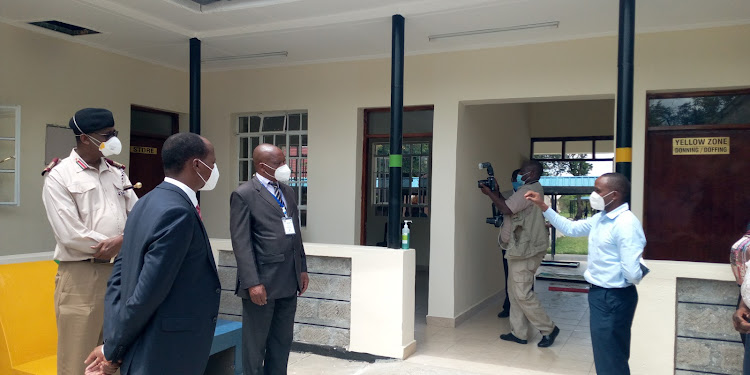 Senior deputy secretary in the Interior ministry Isaac Masinde (R), Makueni county commissioner Maalim Mohammed (in uniform) and Makueni Health CEC Andrew Mulwa (L) tour the county Covid-19 treatment centre at Makueni Referral Hospital.