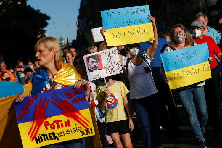 People hold placards against Russia's President Vladimir Putin as they march towards the Obelisk during a protest in support of Ukraine, amid Russia's invasion, in Buenos Aires, Argentina. REUTERS/Agustin Marcarian