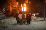 Rescue workers evacuate an injured man from the scene where a suicide car bomb exploded, targeting a Mogadishu hotel in a business centre at Maka-Al-Mukaram street in Mogadishu, Somalia on February 28 2019. 
