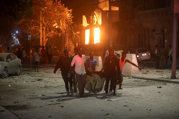 Rescue workers evacuate an injured man from the scene where a suicide car bomb exploded, targeting a Mogadishu hotel in a business centre at Maka-Al-Mukaram street in Mogadishu, Somalia on February 28 2019.