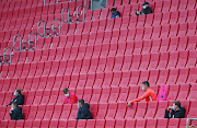 Augsburg players wearing protective face masks in the stands, as play resumes behind closed doors following the outbreak of the coronavirus disease (COVID-19) 