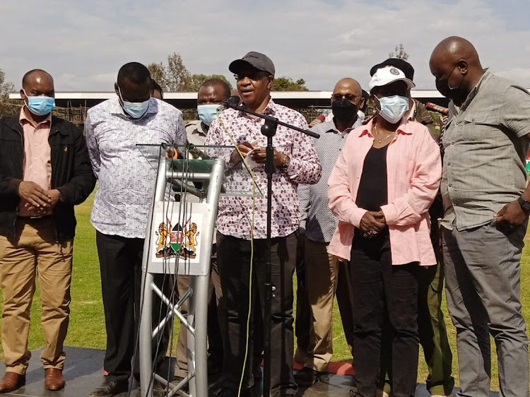 Interior principal secretary Karanja Kibicho in the company of national celebrations committee members addressing the press at the Wang'uru stadium after the committee inspected the stadium and the state of preparations in readiness for Mashujaa event.