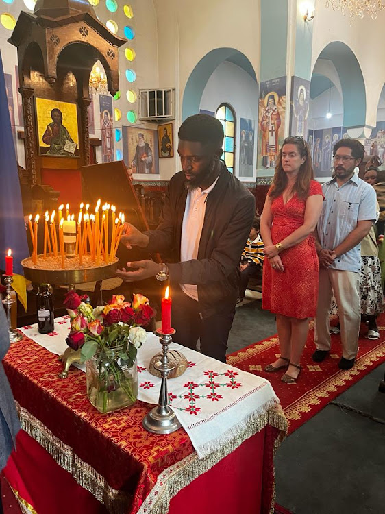 The Star journalist Brian Oruta places a candle in a sandbox during the commemoration service for the victims of the Holodomor genocide at the Orthodox Patriarchal Cathedral of Sts. Cosmas and Damian, on Valley road, Nairobi on November 25, 2023.