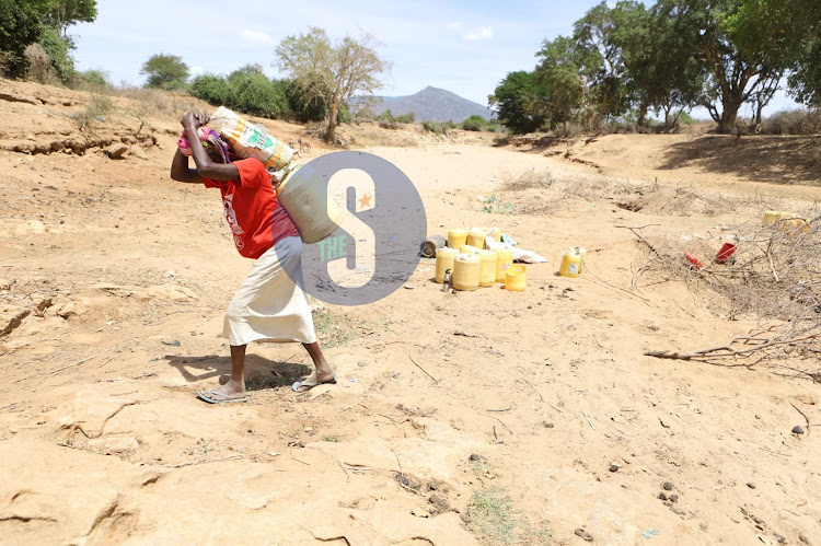 Rose Kaluma carrying a water jerican from a well on dried up Voi River, Mwatate, Taita Taveta on November 3, 2022.