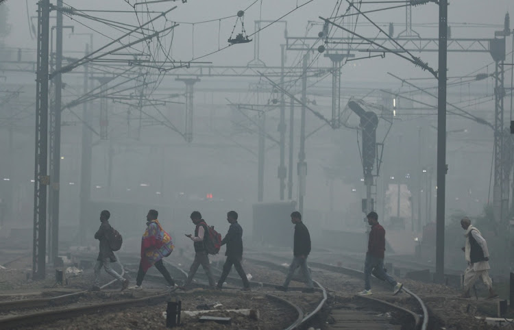 People cross railway tracks on a smoggy morning in New Delhi, India on November 3 2023. Picture: REUTERS/Anushree Fadnavis