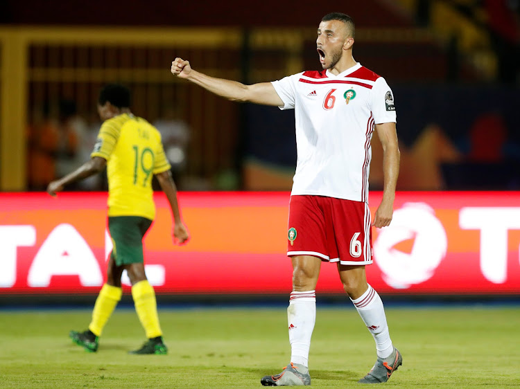 Bafana Bafana star forward Percy Tau looks dejected as Romain Saiss celebrates after Morocco beat South Africa with a last-gasp goal in their Africa Cup of Nations Group D final group match in Cairo, Egypt, on Monday July 1 2019.