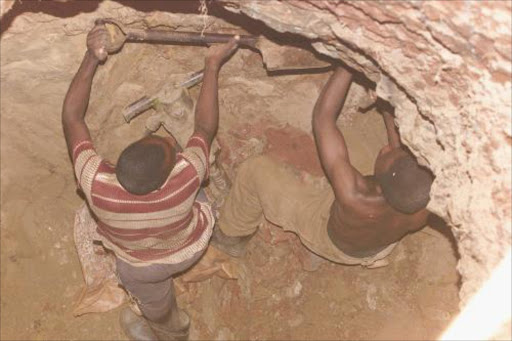 Local inhabitants of Barberton, Mpumalanga, started mining gold in their own informal gold mine: initially they made money but when the government regulated the industry, they no longer made much profit. Bheki Nkosi and Shali Metise dig in search of gold. Pic. Thembinkosi Dwayisa. 15/2/02. © ST.